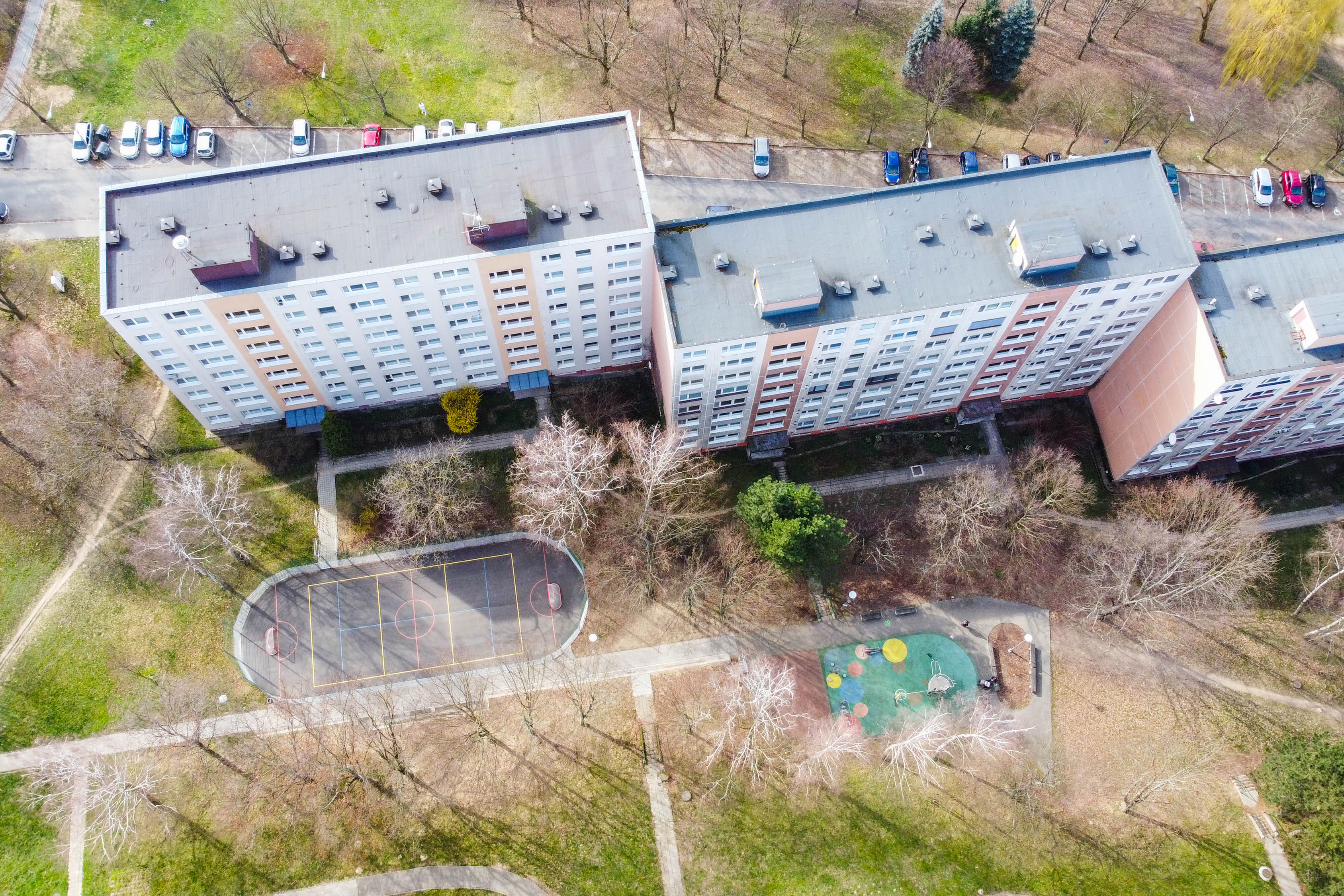 hřiště vedle panelového domu z dronu